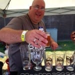 David "Yogi" Dean, festival volunteer, pours beer for Bridge Brew Works at the Rails & Ales Craft Beer Festival