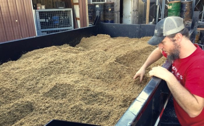 Brian Arnett looks at the spent grain that will be picked up by a local farmer.