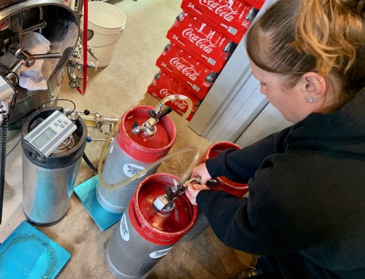 Kristin Johnson at work filling and weighing kegs.