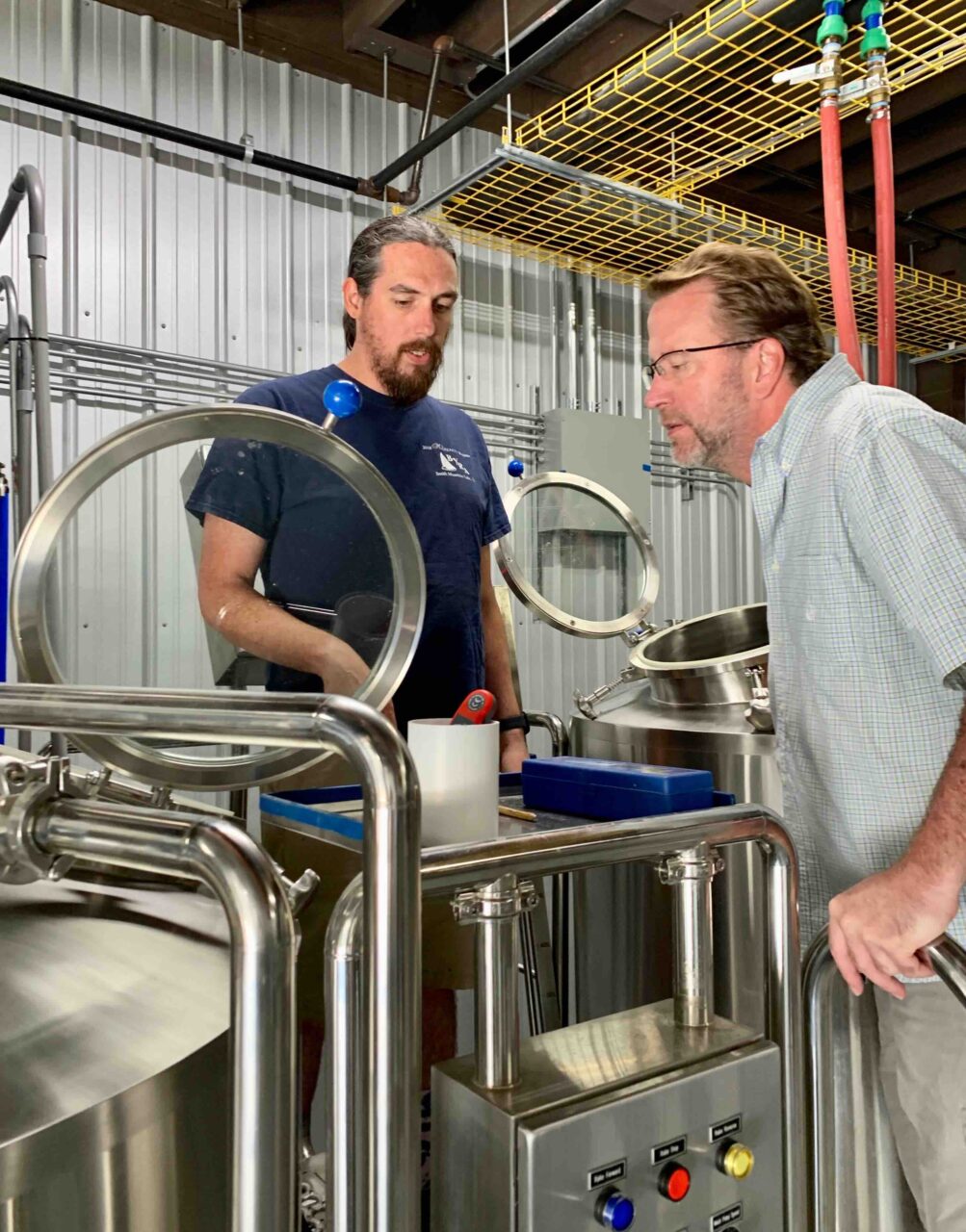 Lawrence Walkup and Yuri Eure on the brewing stand at Old Spruce Brewing in West Virginia